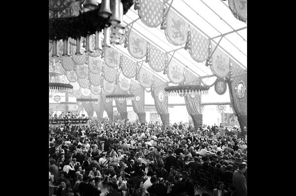 Vintage photo of the Big giant tent at Oktoberfest filled with party goers in Germany. This is a normal sight if you were to visit even to this day.