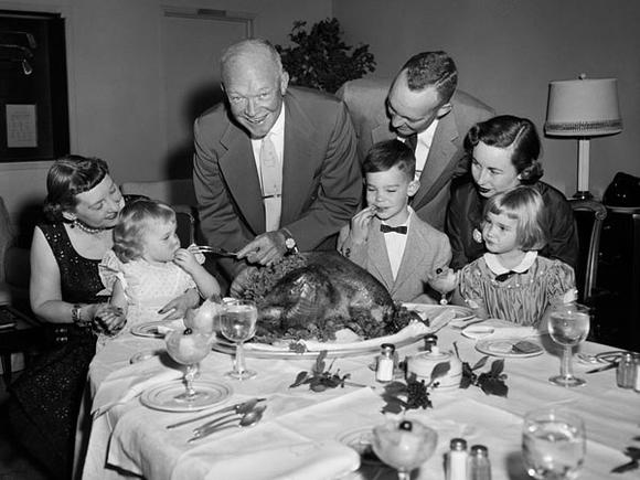1950's thanksgiving-Vintage 1950s photo of a family sitting around the thanksgiving dinner table about to carve the turkey. 