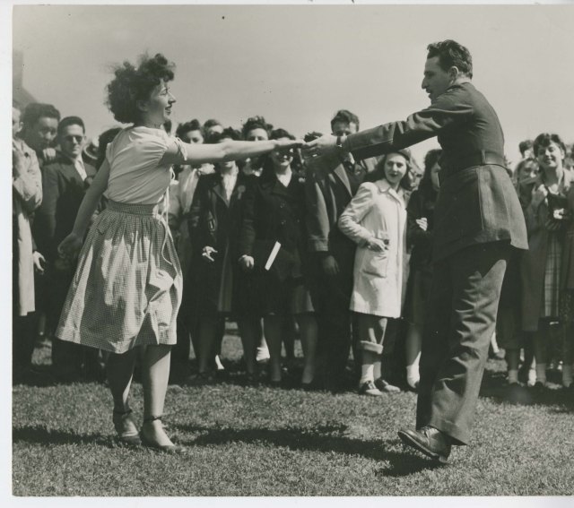 1940s vintage photo of a couple swing dancing at a country fair. 