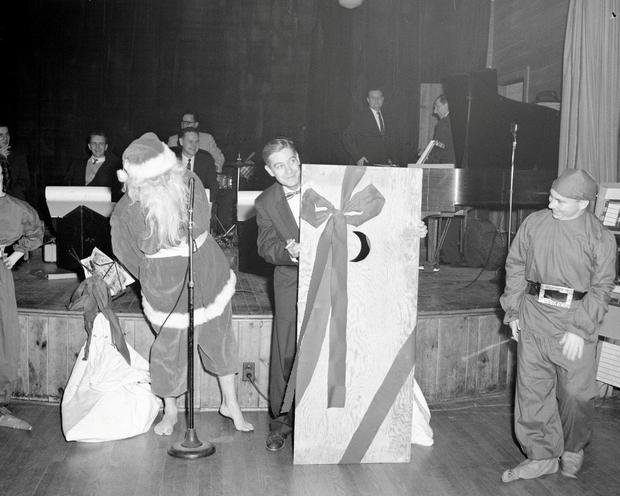 1940s vintage christmas party photo featuring an image of Santa with no shoes on. 