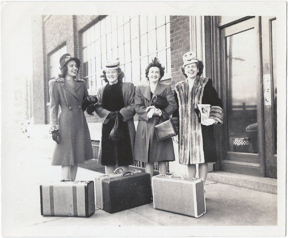 1940s vintage photo of Four women with suitcases and in stunning 1940s winter coats and 1940s hats posing before heading out on trip. Super 1940s fashions. 