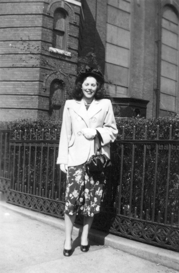 1940s vintage photo of a young woman in a floral dress and stunning 1940s jacket and hat and purse. Fantastic 1940s fashion inspiration! 