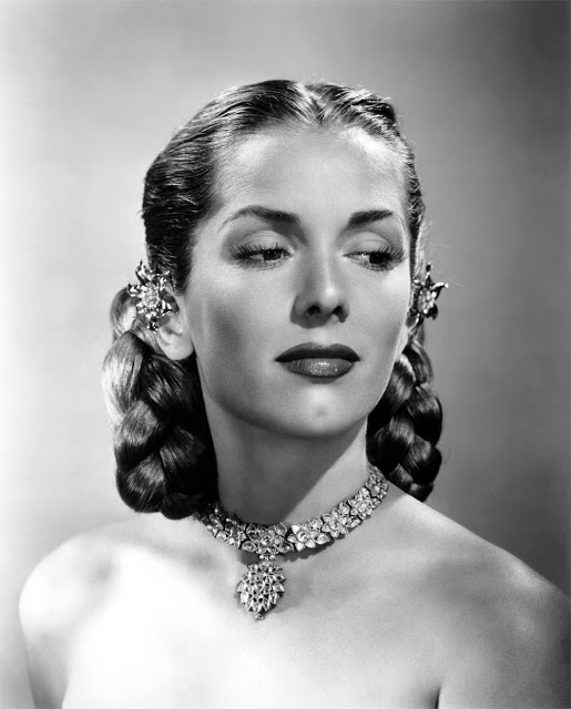 1940s vintage photo of Jinx Falkenburg with a 1940s hairstyle with hair clips by her ears posing for a modeling photo. 