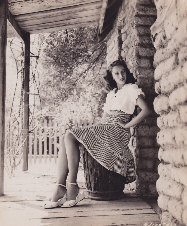 1940s vintage photo of Jinx Falkenburg in the classic movie Nine Girls in 1944. Jix is wearing a peasant top and a cute 1940s skirt with 1940s shoes and 1940s hairstyle. Super 1940s fashion!