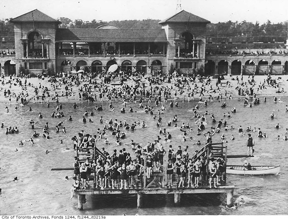 1920s vintage photo of a large amount of people enjoying the water and beach at Sunnyside Beach and Pavilion.