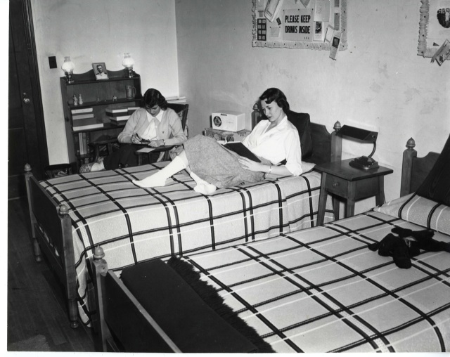 1940s vintage photo  of two young women in their college dorm studying. 