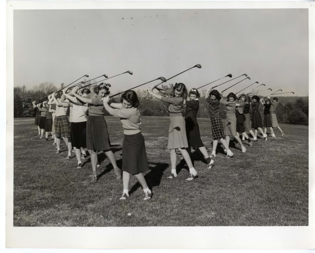 1940s vintage photo of young women in college in 1940s fashions and saddle shoes posing with their golf clubs for their Golf Club. 